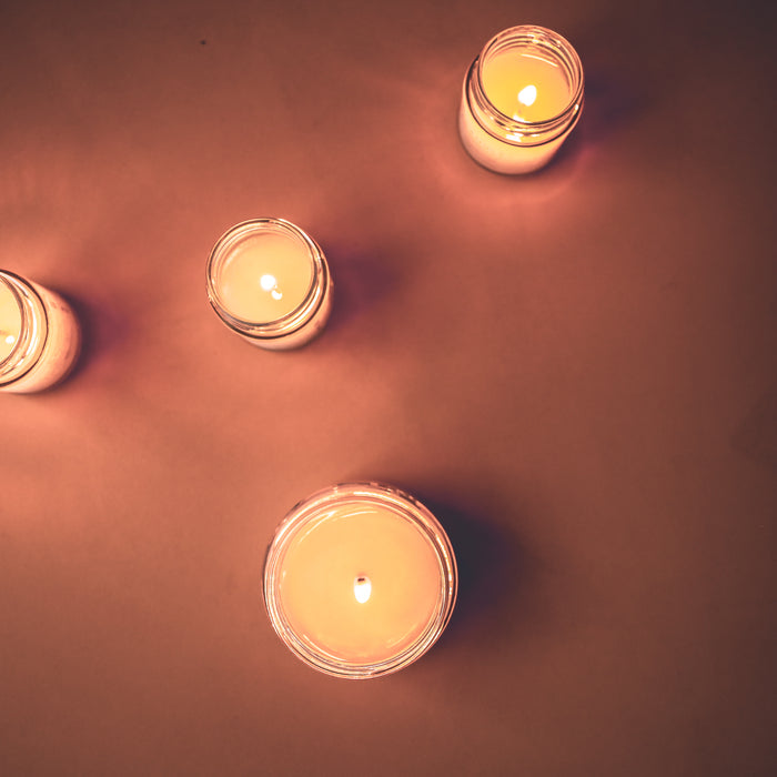 Four lit candles in dark orange background